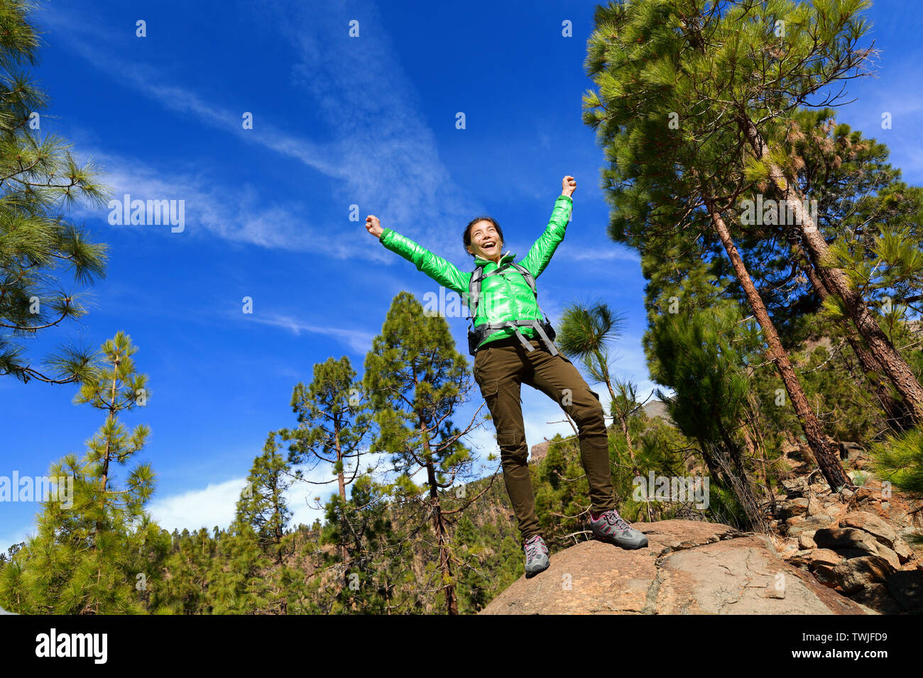 Randonnées woman reaching haut sommet cheering célébrant en montagne avec les bras tendus vers le ciel. Happy female hiker. Banque D'Images