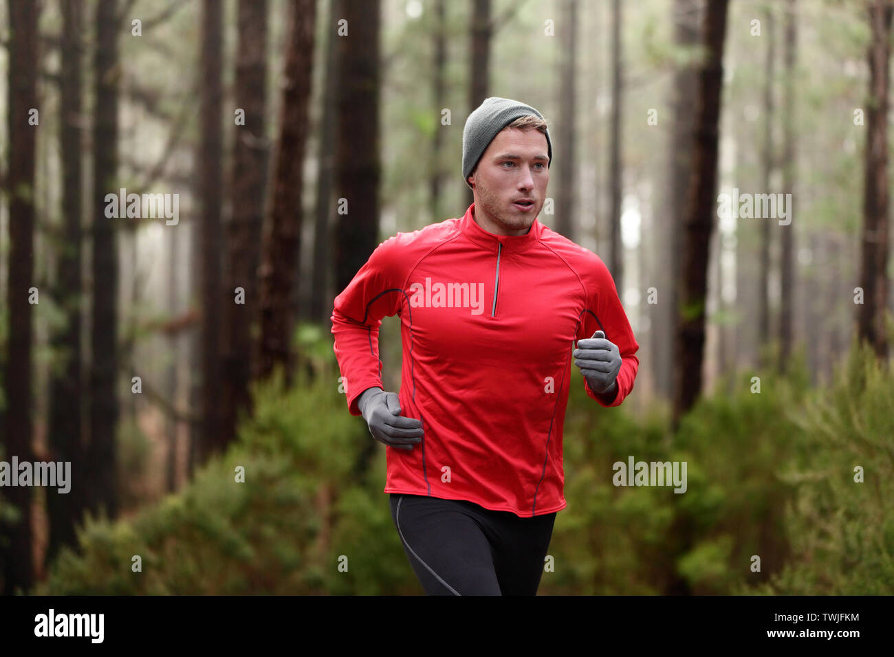 Homme en train de courir dans les bois de la forêt de formation et d'exercices pour l'exécution de la course d'endurance trail marathon. Vie saine remise en forme de l'athlète masculin avec concept Trail Runner. Banque D'Images