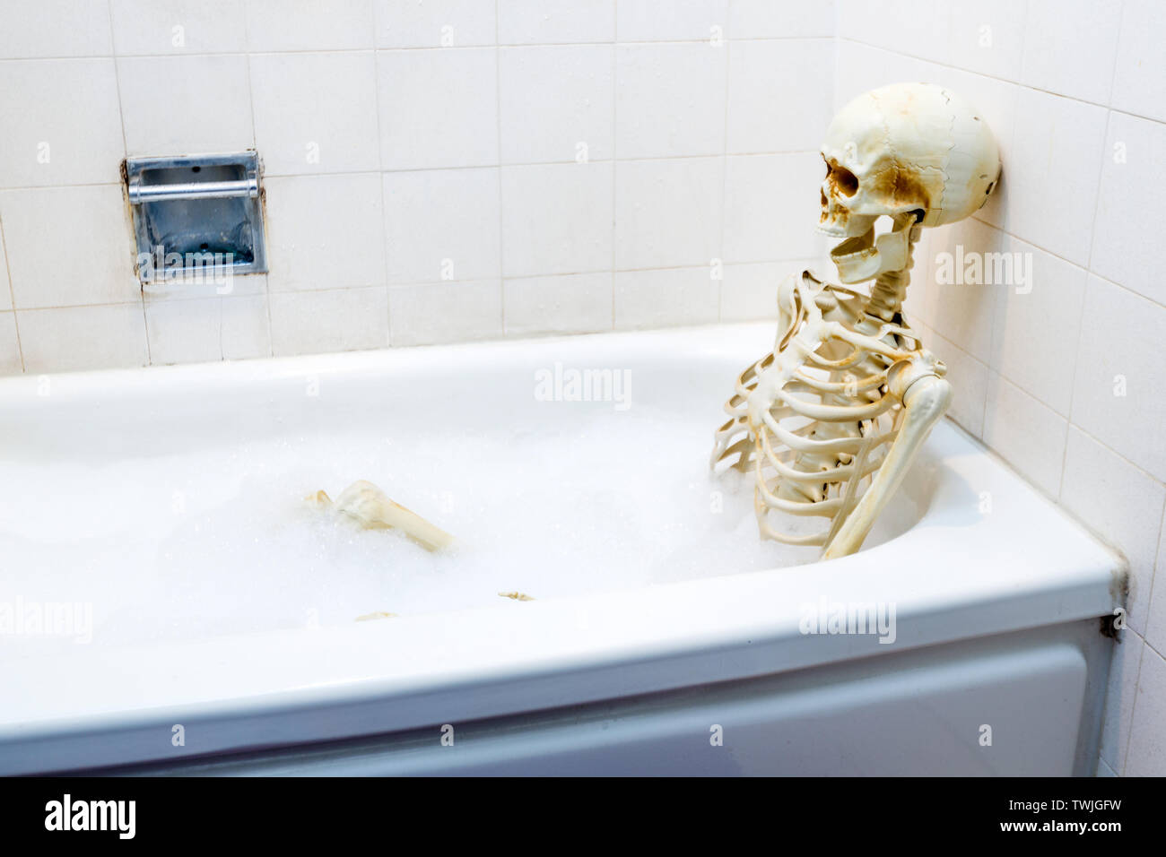 Squelette osseux prenant un bain moussant dans une grungy baignoire sale  off-white Photo Stock - Alamy