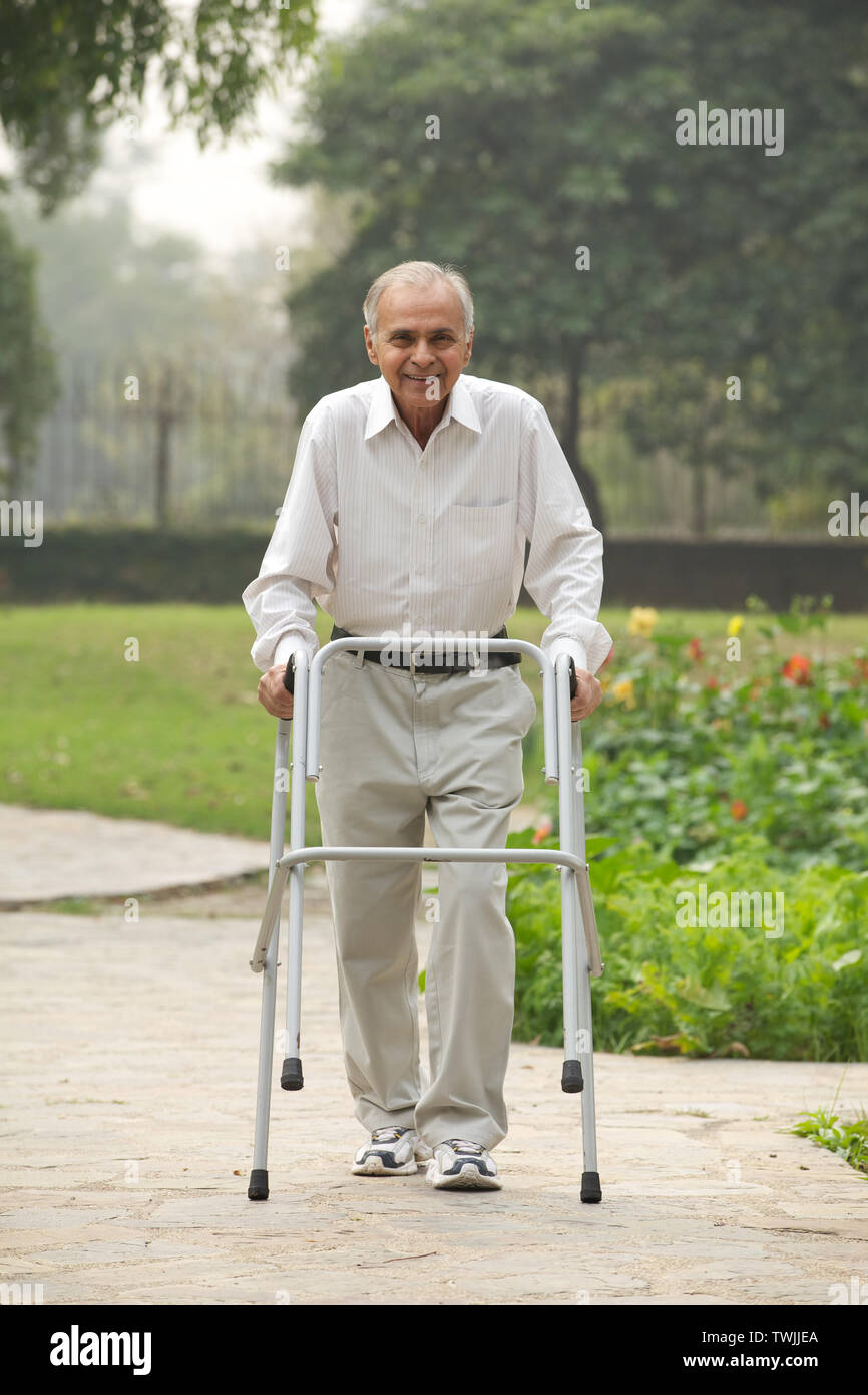 Vieil homme à marcher avec un déambulateur Banque D'Images