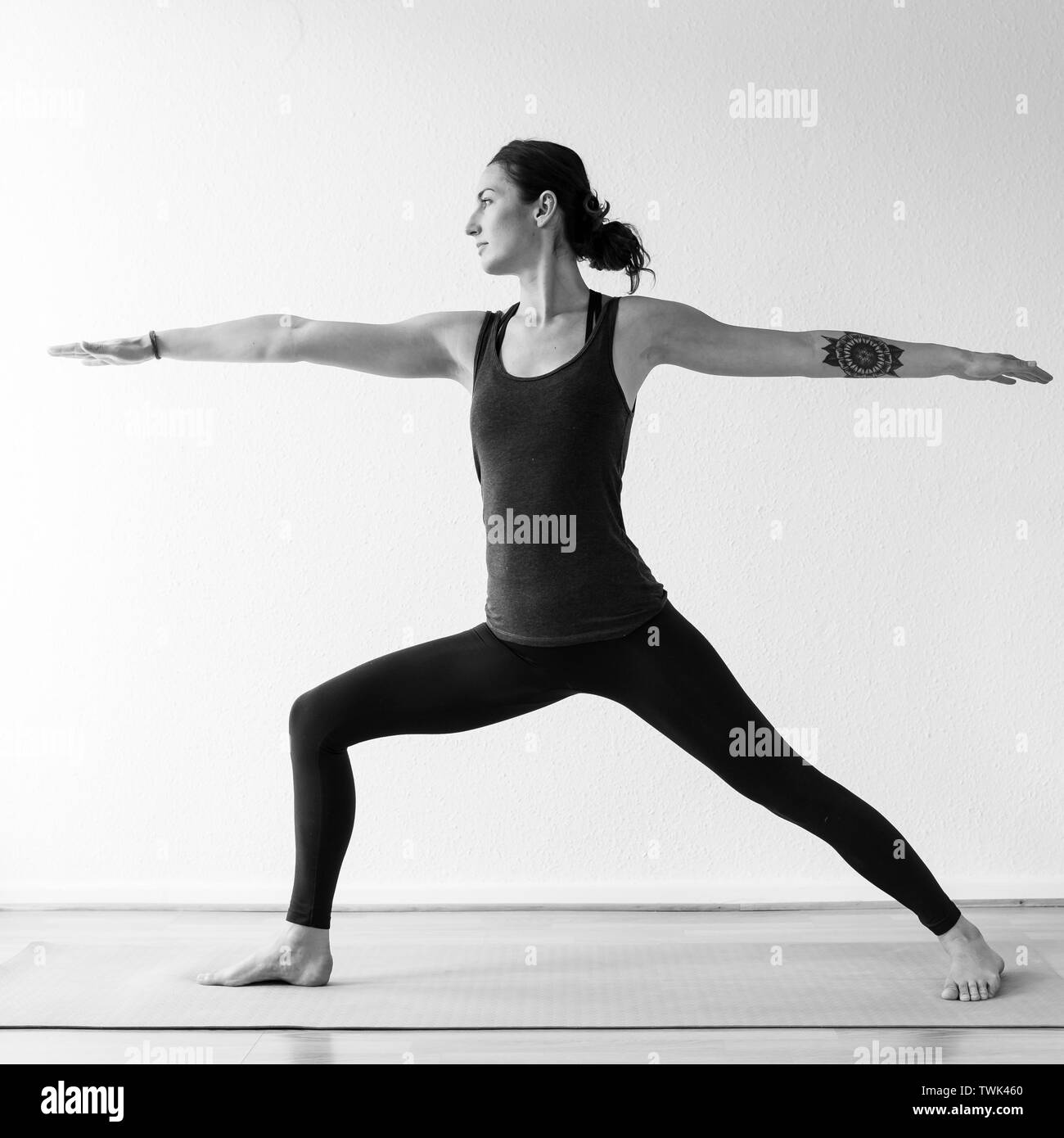 Un dark-haired femme européenne dans son 30 ans pratique le yoga à la maison. La méditation de pleine conscience, d'étirements et d'atteindre la santé physique et spirituelle. Vert Banque D'Images