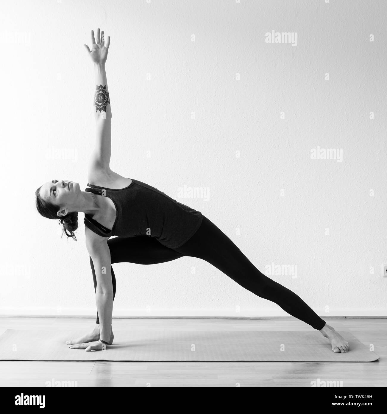 Un dark-haired femme européenne dans son 30 ans pratique le yoga à la maison. La méditation de pleine conscience, d'étirements et d'atteindre la santé physique et spirituelle. Vert Banque D'Images