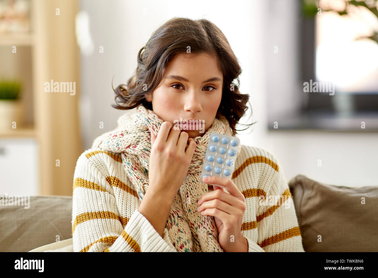 Femme malade dans la médecine avec écharpe comprimés à la maison Banque D'Images