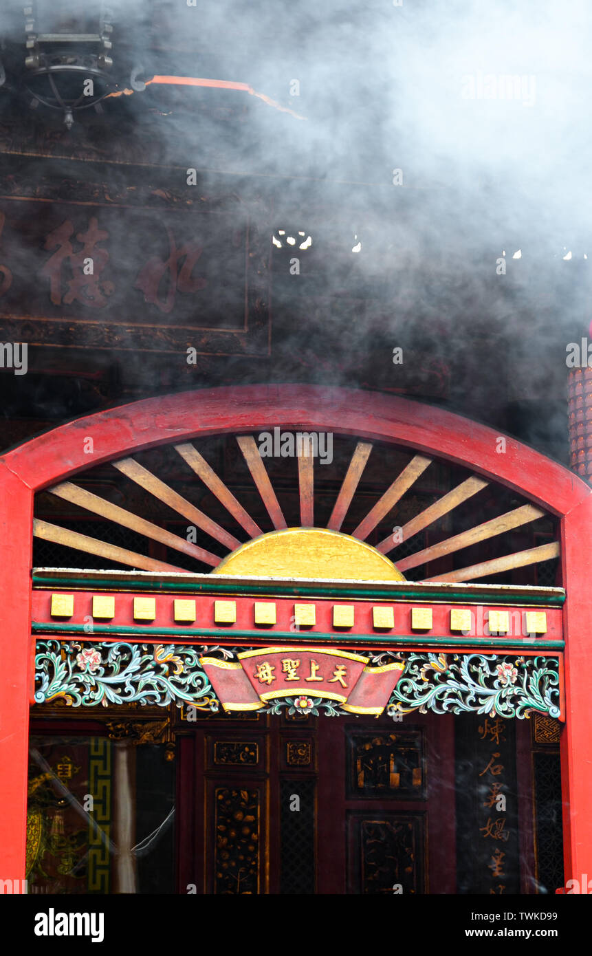 Taipei, Taiwan - 13 mai 2017 : porte d'entrée Rouge avec nuage de fumée au-dessus dans le Temple Bouddhiste. Lieu de culte pour la religion traditionnelle chinoise avec éléments bouddhistes. Concept religieux, symboles, résumé. Banque D'Images