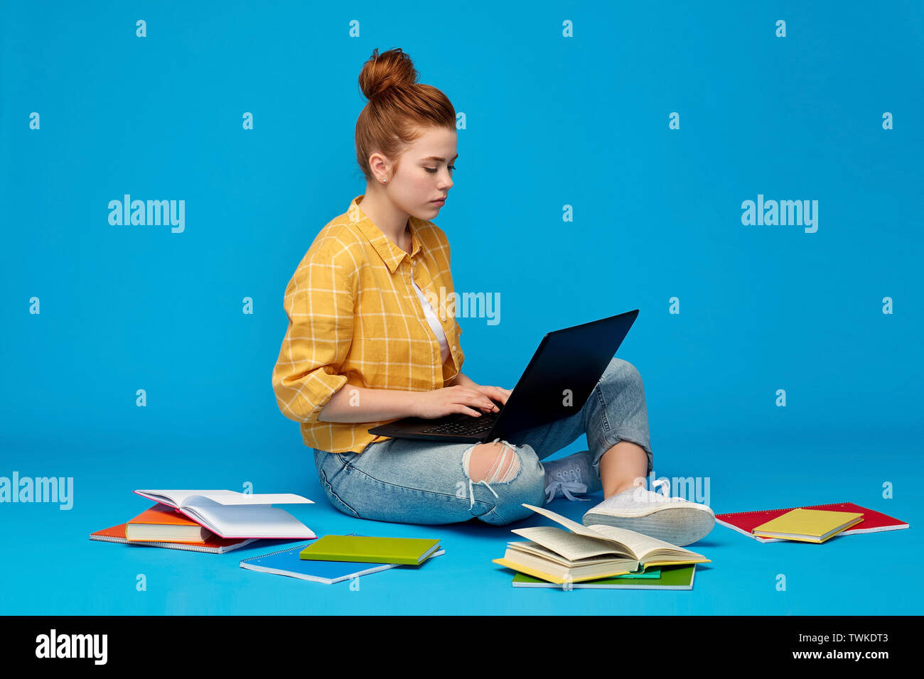 Redhead teenage student girl with laptop and books Banque D'Images