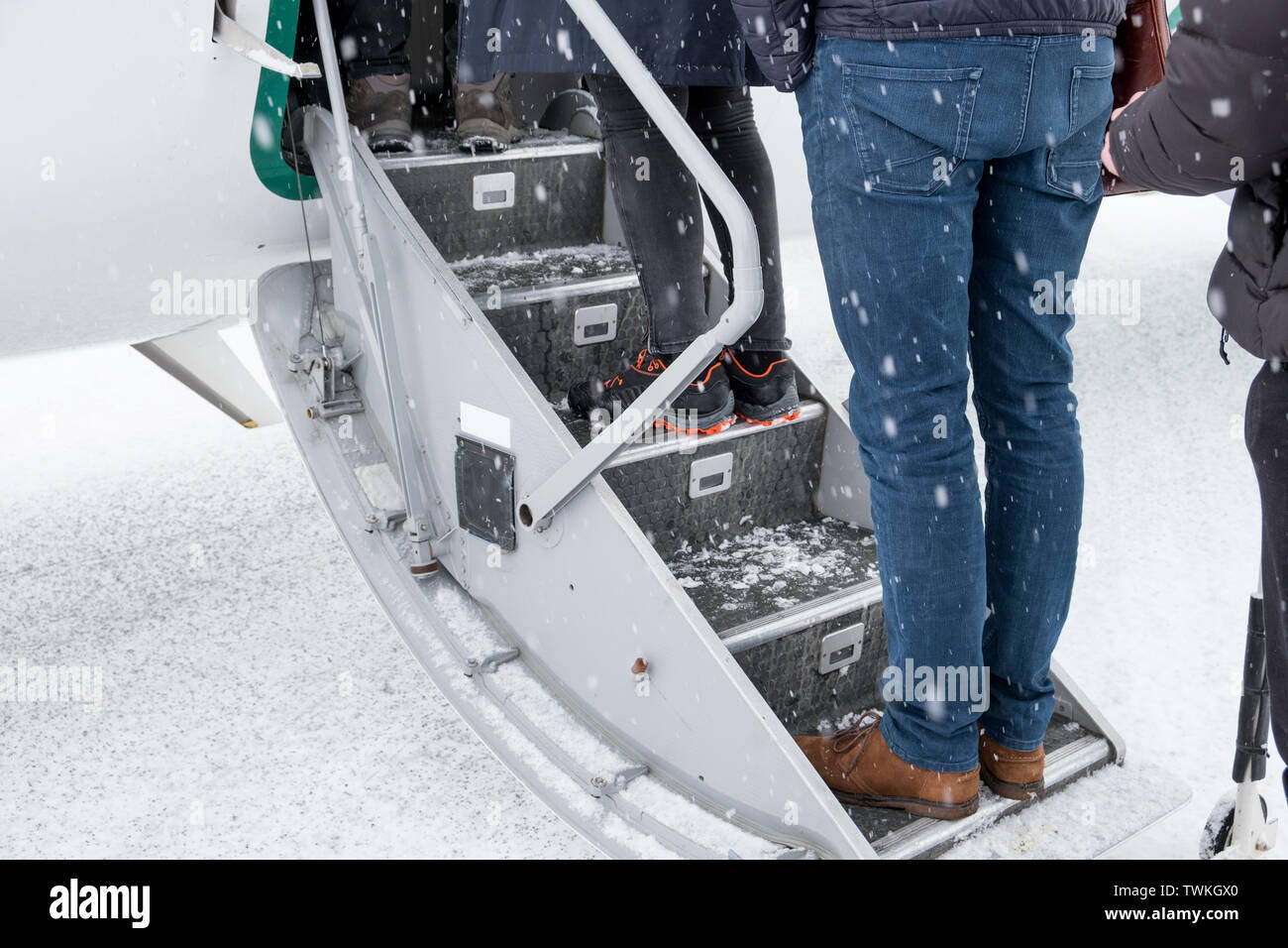 Passagers en attente d'conseil d'avion sur un jour de neige Banque D'Images