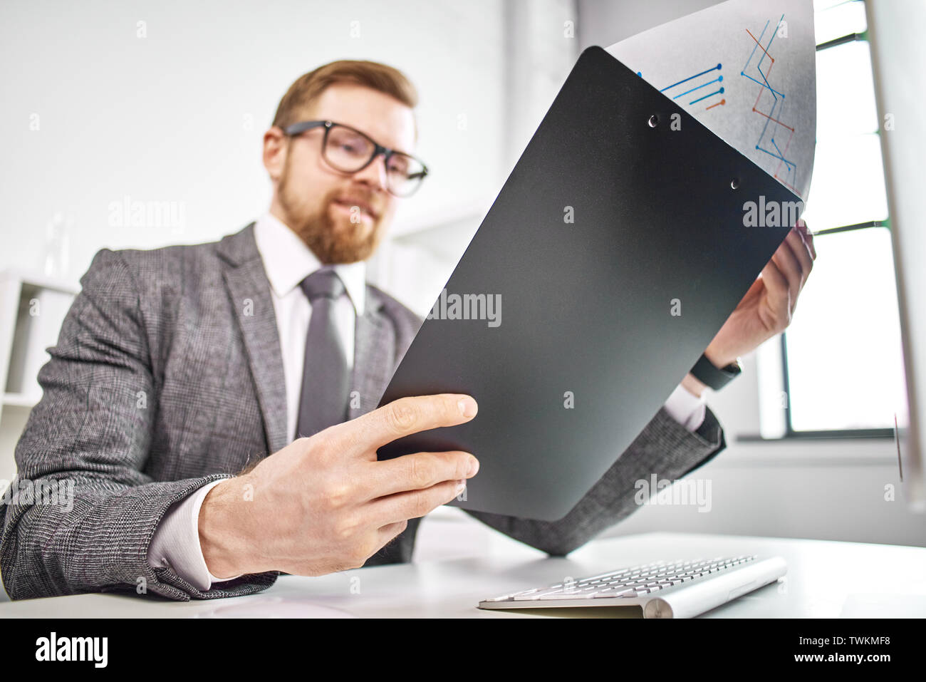 Homme d'âge moyen de travailler avec les documents à computer in office Banque D'Images