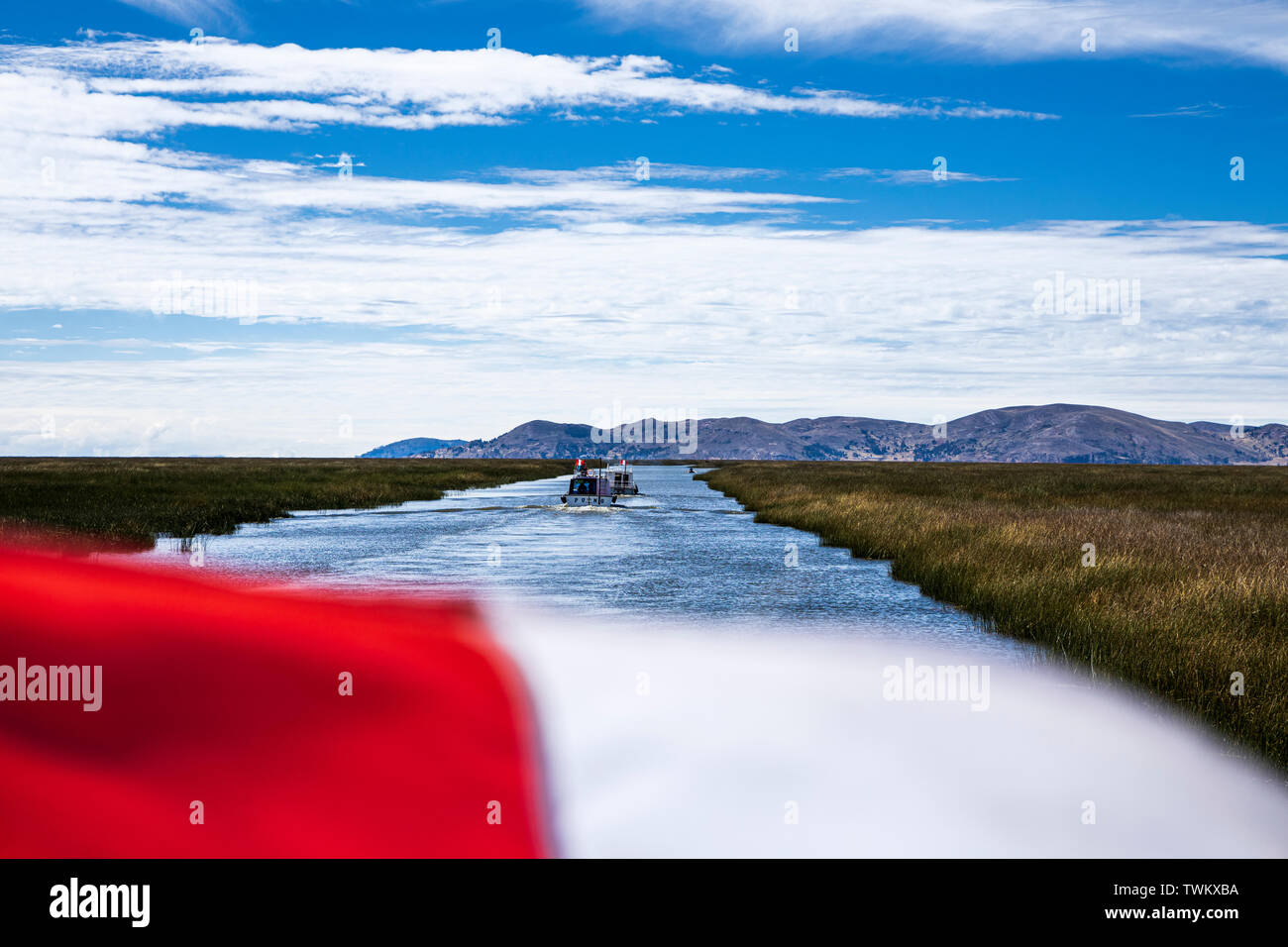 Le rouge et le blanc du drapeau national péruvien battant sur un bateau sur le lac Titicaca, le Pérou, Amérique du Sud Banque D'Images