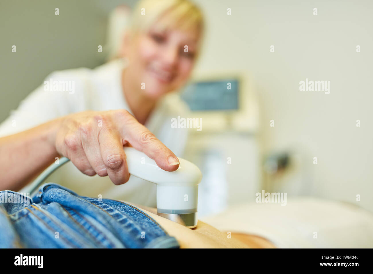 Docteur fait thérapie par ultrasons dans le patient sur la colonne lombaire pour le soulagement des maux de dos Banque D'Images