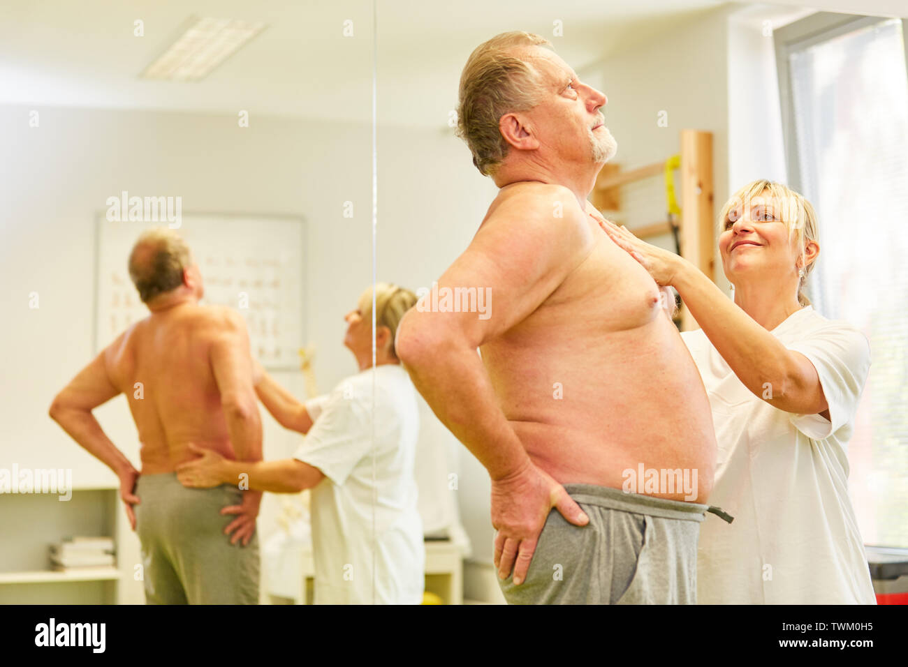 Les non-médecin traite senior patient avec le rachis lombaire douleur au dos en physiothérapie Banque D'Images