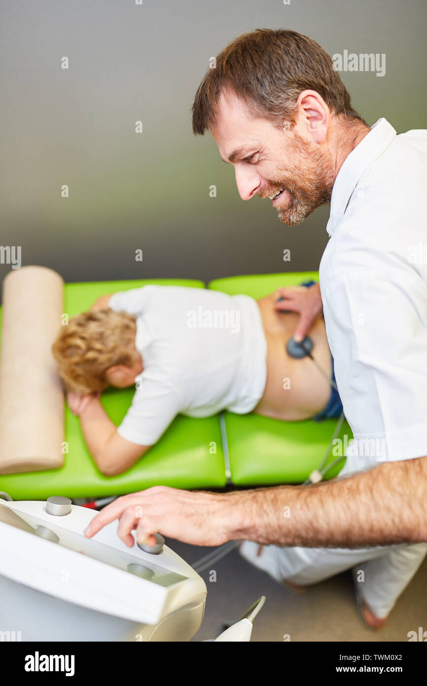 Médecin et patient avec la stimulation thérapie actuelle comme un traitement de la douleur et pour la circulation sanguine Banque D'Images