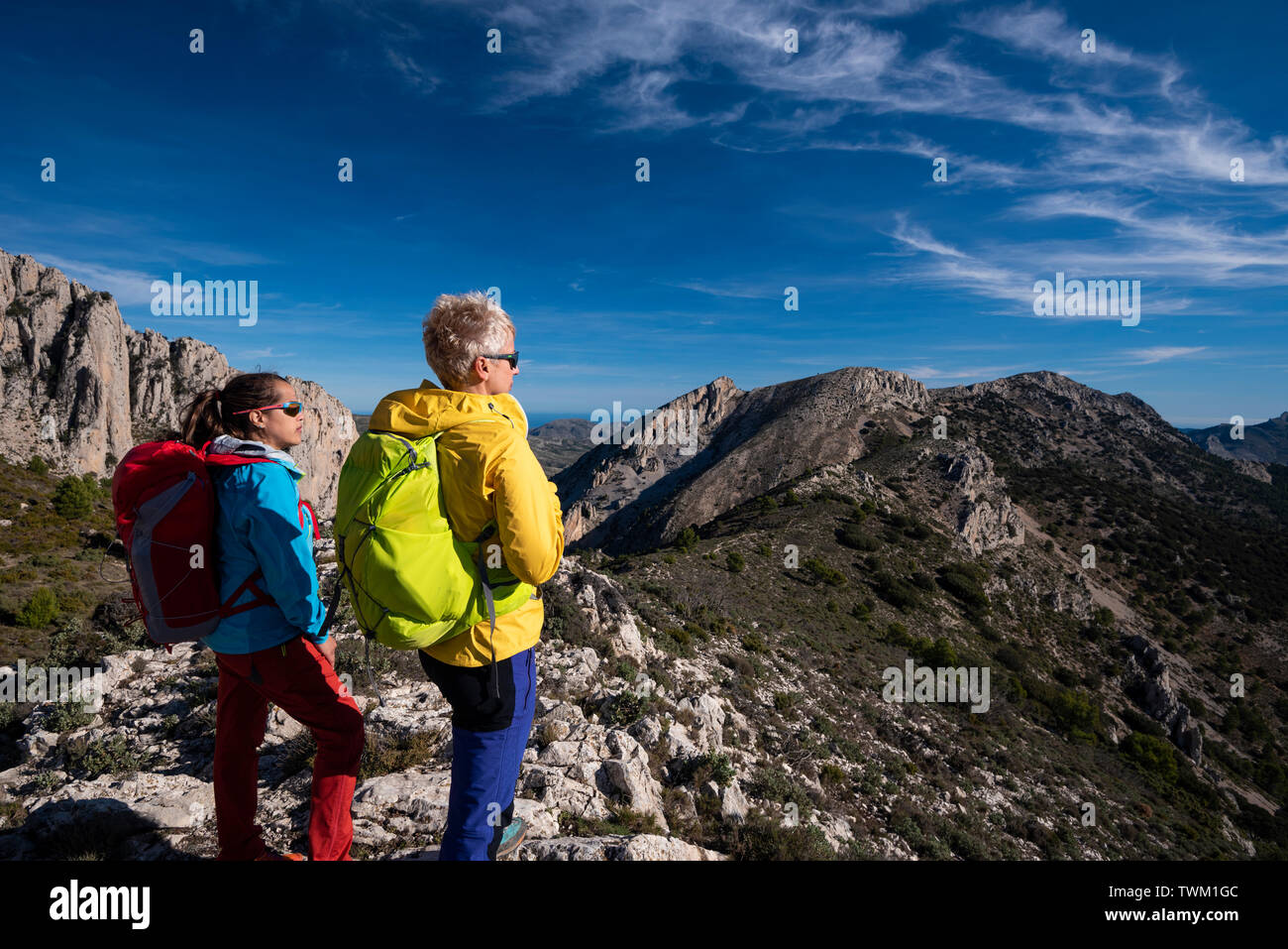 Deux femmes sur une randonnée à la recherche vers la vallée, randonnées dans la Sierra de Serrella, Quatretondeta-Confrides, province d'Alicante, Valence région, Banque D'Images