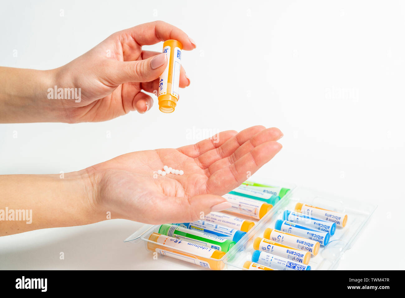 Tubes homéopathiques : granules homéopathiques, tubes de la laboratoires Boiron. Woman putting granules homéopathiques dans sa main Banque D'Images