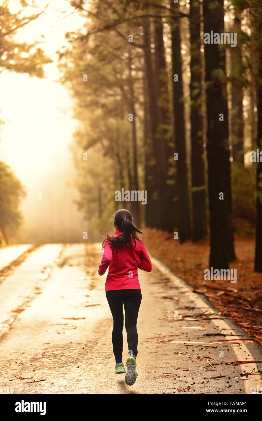 En cours d'exécution sur l'athlète en route morning sunrise pour marathon de formation et de remise en forme. Mode de vie sain et actif woman exercising outdoors. Banque D'Images