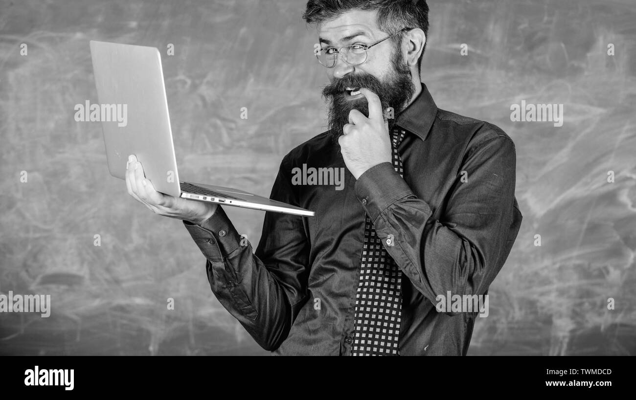 Lifehack de l'école. Professeur Hipster portent des lunettes et cravate est titulaire d'ordinateur portable Internet surf. L'homme rusé barbu enseignant portable moderne tableau internet surf arrière-plan. Des informations intéressantes. Banque D'Images