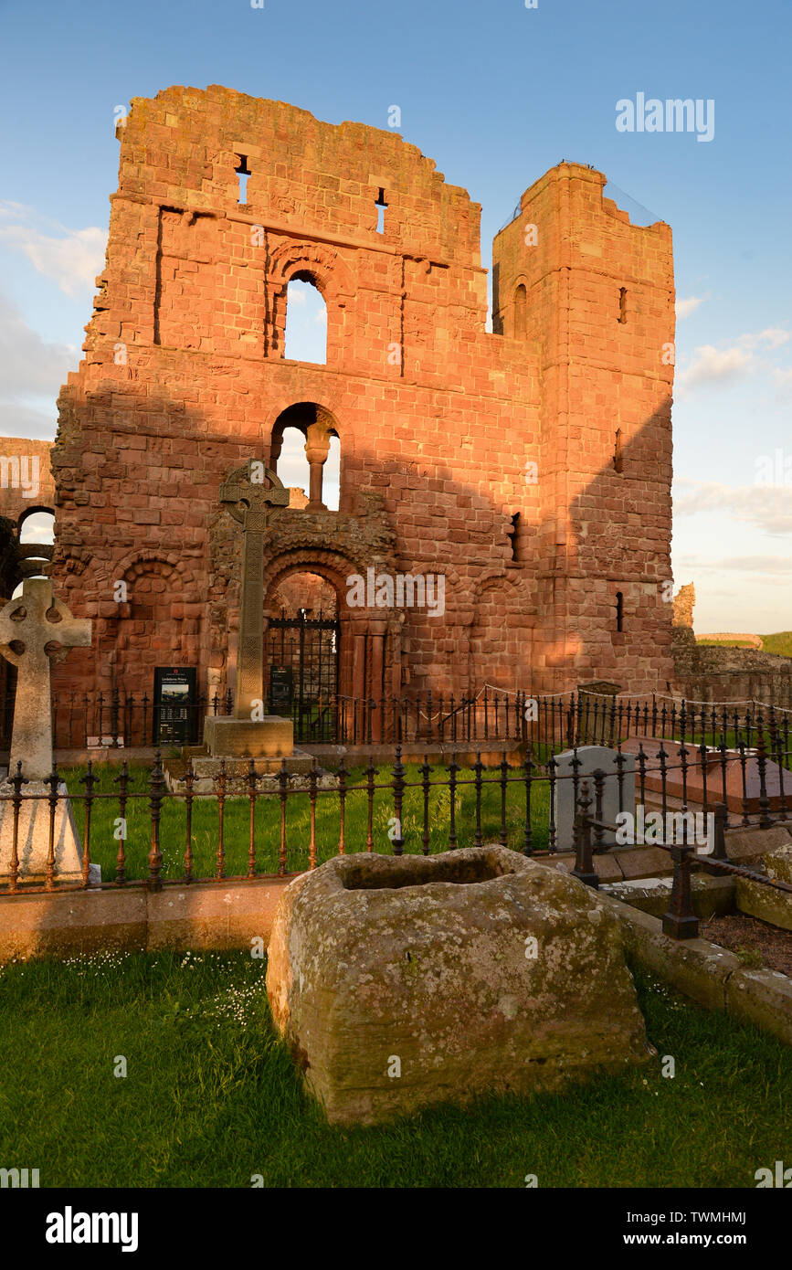 La 'pierre' Louping à Lindisfarne église paroissiale avec le prieuré au-delà, des brides par tradition jump (loup) au cours de la Louping Pierre pour la bonne chance. Banque D'Images