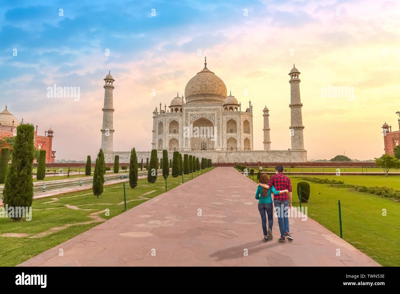Couple de touristes au Taj Mahal Agra Inde au lever du soleil. Taj Mahal est un chef-d'architecture moghole, désigné comme site du patrimoine mondial de l'UNESCO Banque D'Images