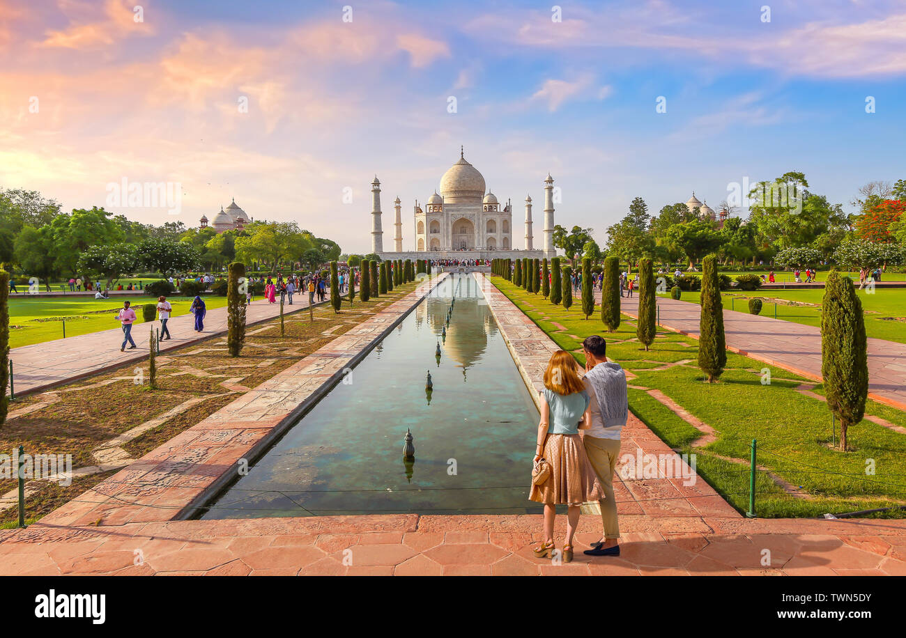 Mausolée en marbre blanc du Taj Mahal au coucher du soleil avec vue sur le couple de touristes de profiter de la vue à Agra, Inde Banque D'Images
