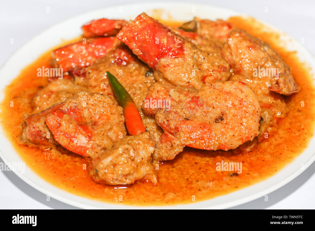 La nourriture épicée indienne curry de crevettes préparées à la noix de coco servi comme accompagnement avec du riz isolé sur fond blanc Banque D'Images