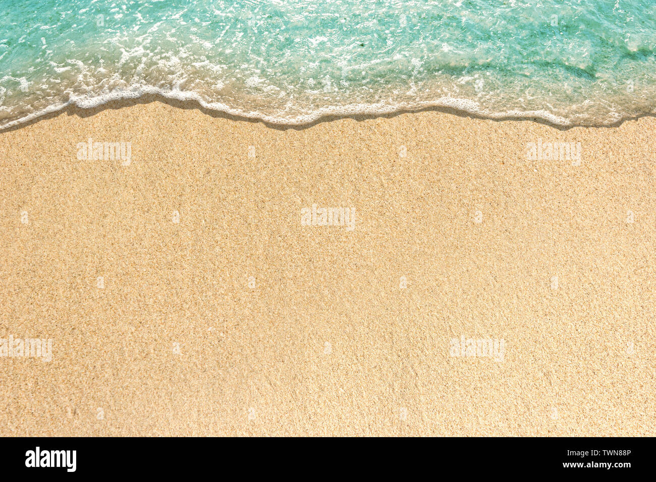 Vagues douces avec mousse de bleu océan sur la plage de sable Banque D'Images