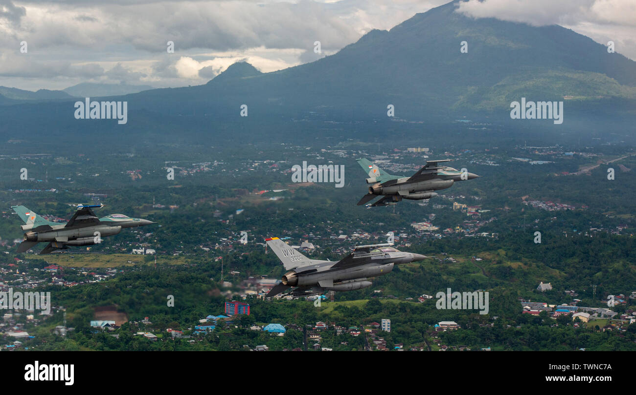 Un U.S. Air Force F-16 Fighting Falcon fighter pilot vole aux côtés de deux Indonesian air force F-16 Fighting Falcon fighter pilots sur Manado, Indonésie, au cours de faire face à l'Ouest 19, 20 juin, 2019. Faire face à l'Ouest est un deux semaines, Pacific Air Forces parrainé, exercice bilatéral visant à accélérer l'interopérabilité et de s'appuyer sur des partenariats déjà établis entre les forces militaires américaines et de l'Indonesian air force. L'exercice permet aux deux pays d'échanger sur les techniques de production et de récupération d'aéronefs, l'appui aérien rapproché de la formation, de la formation et de l'hôte sous réserve de chasse-mat Banque D'Images