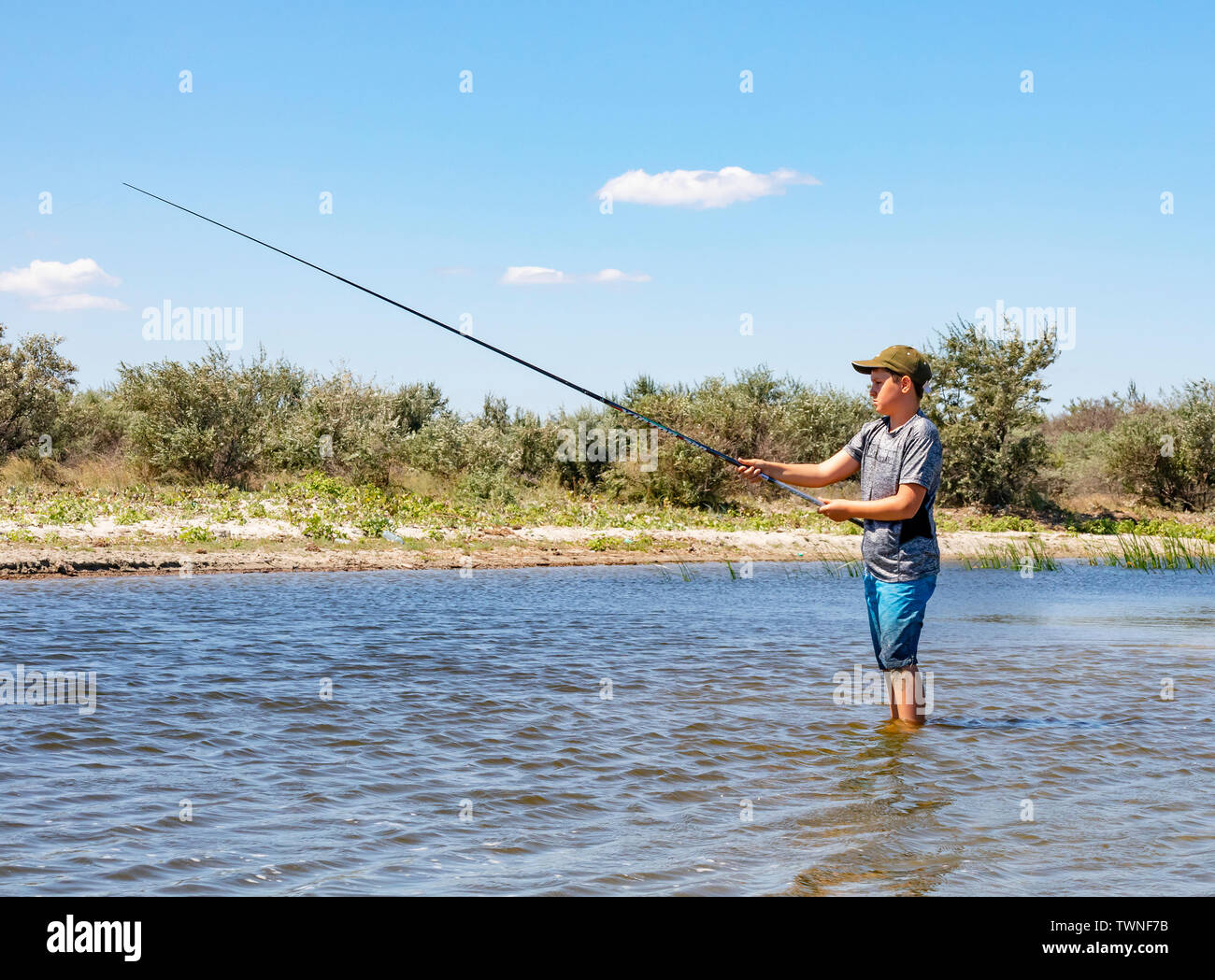 Sulina, Roumanie - un garçon de pêche dans le Danube près de Sulina, Roumanie, lors d'une journée ensoleillée Banque D'Images