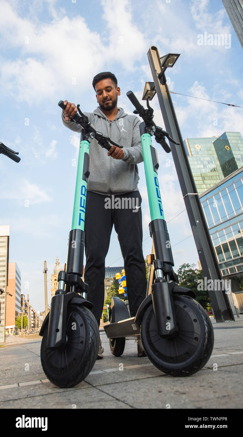 22 juin 2019, Hessen, Frankfurt/Main : Haseeb Rafiq du fournisseur d  'Liefery» met en place un scooter électrique à Willy-Brandt-Platz.  L'entreprise de niveau de mobilité" lance l'e-scooter Location du samedi.  Un maximum