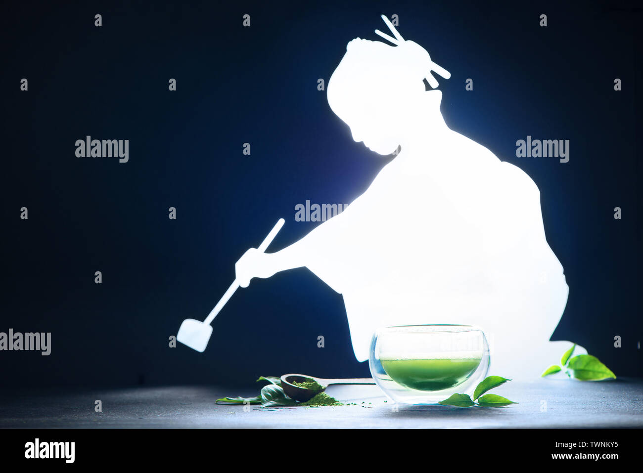 Cérémonie du thé avec une silhouette de femme brillante brewing thé matcha. Verre double paroi sur l'arrière-plan foncé with copy space Banque D'Images