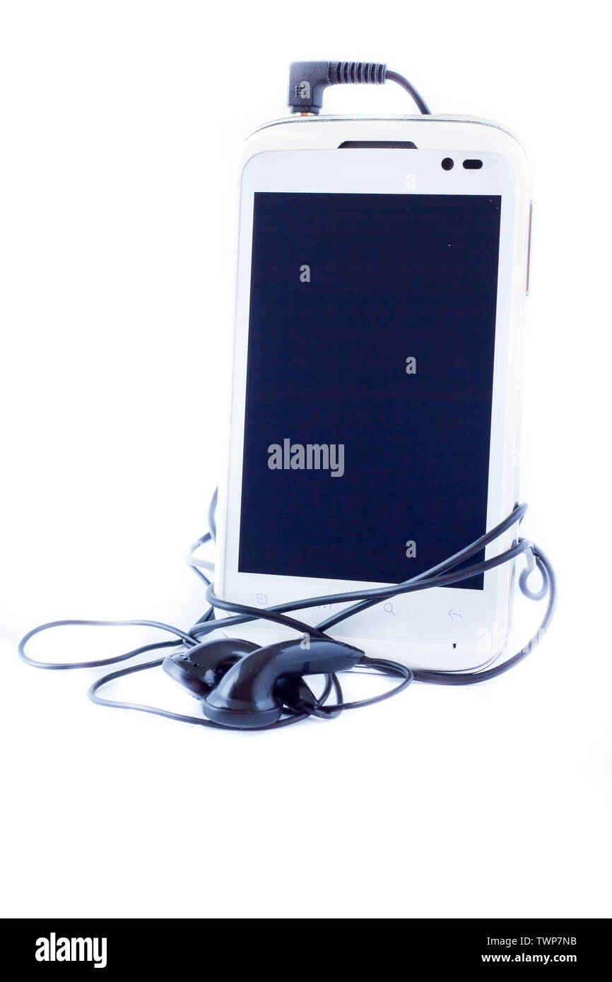 Téléphone cellulaire avec casque sur fond blanc Banque D'Images