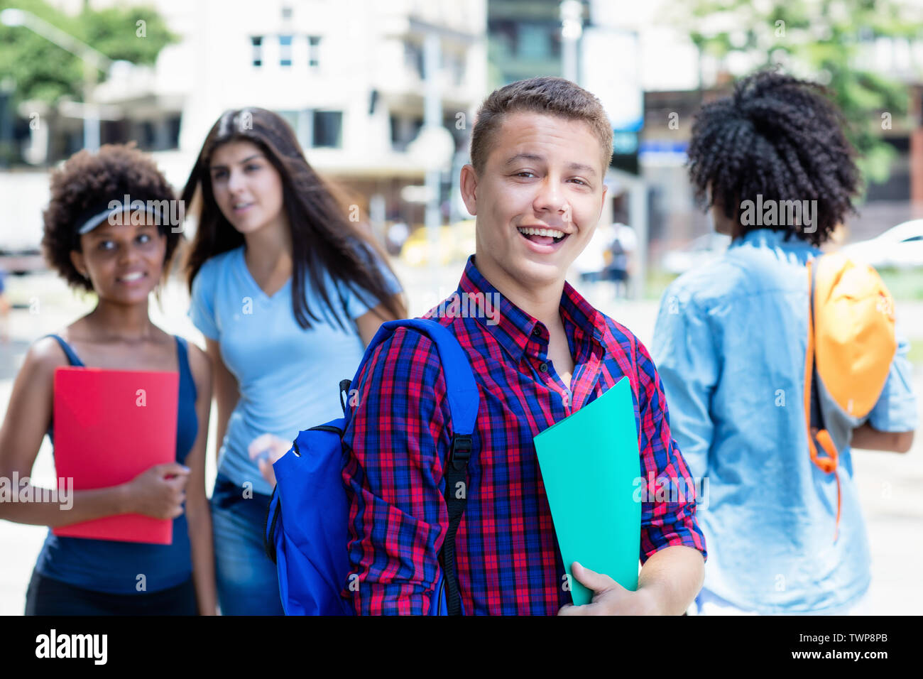 Étudiant brésilien rire avec groupe d'étudiants à l'extérieur en ville en été Banque D'Images