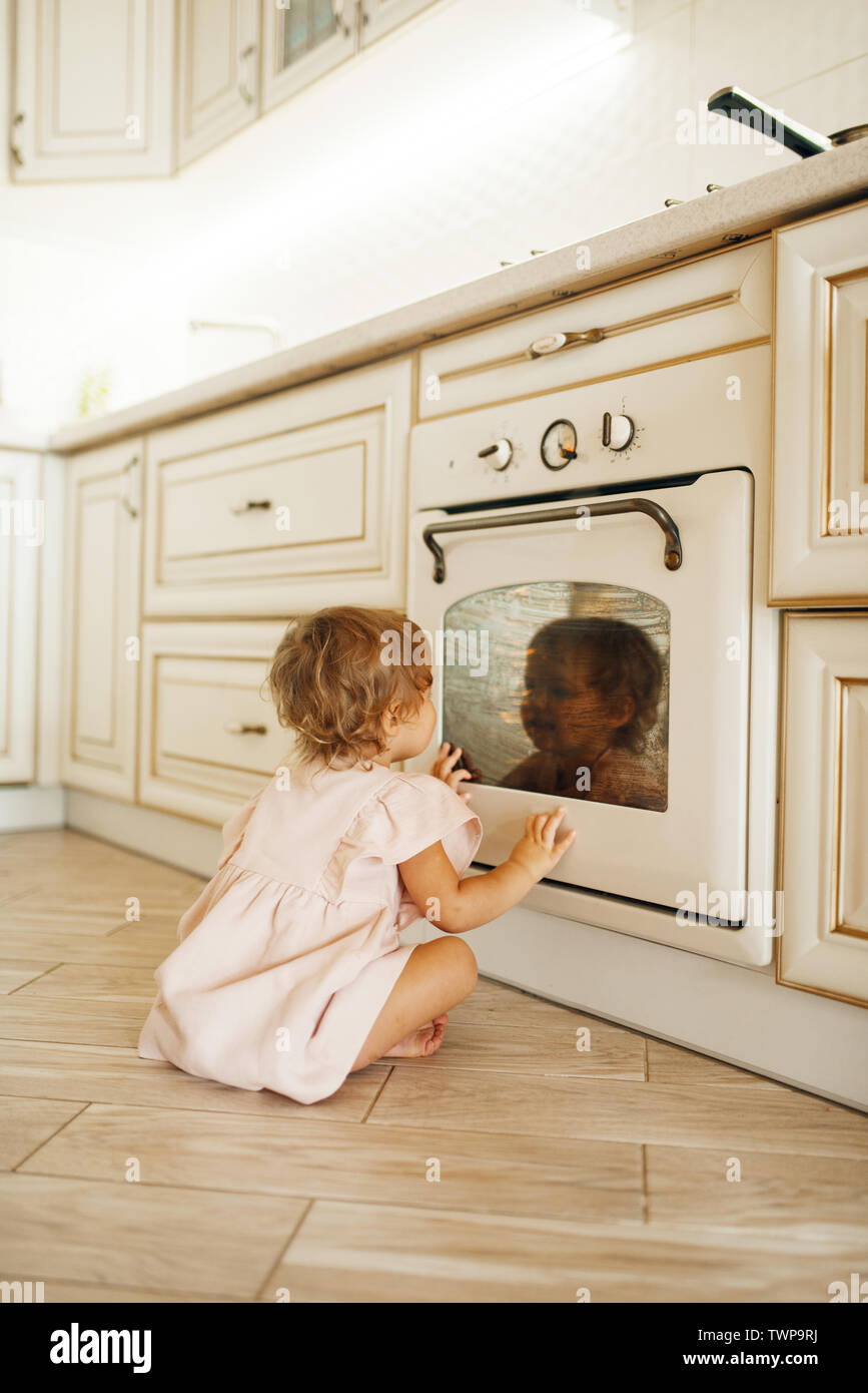 Femme enfant assis sur le plancher à la four Banque D'Images