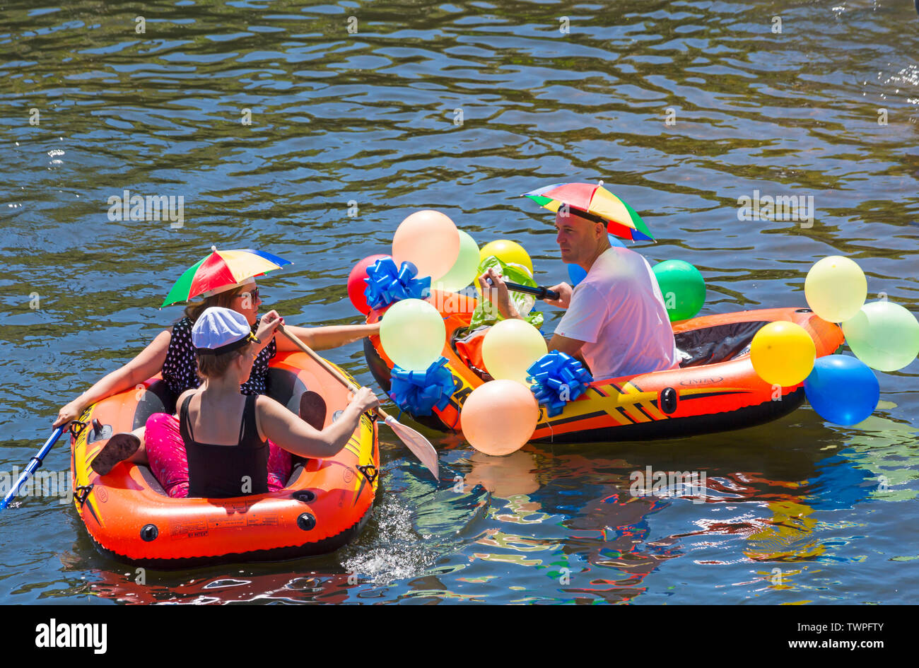 Iford, Dorset, UK. 22 juin 2019. Un temps magnifique, ensoleillé et chaud, toujours pour Dorset Canot Journée avec des centaines de jeux gonflables, des dériveurs, artisanat, conseils formant une flottille, de mettre les voiles de l'IFORD pont rivière Stour de Tuckton bridge. L'événement a commencé en 2014 comme un petit peu de plaisir, mais est maintenant devenu un événement annuel recueillant des fonds pour des organismes de bienfaisance et fonceur plus grand chaque année. S'amusant dans un bateau pneumatique avec ballons et portant des chapeaux de parapluie. Credit : Carolyn Jenkins/Alamy Live News Banque D'Images