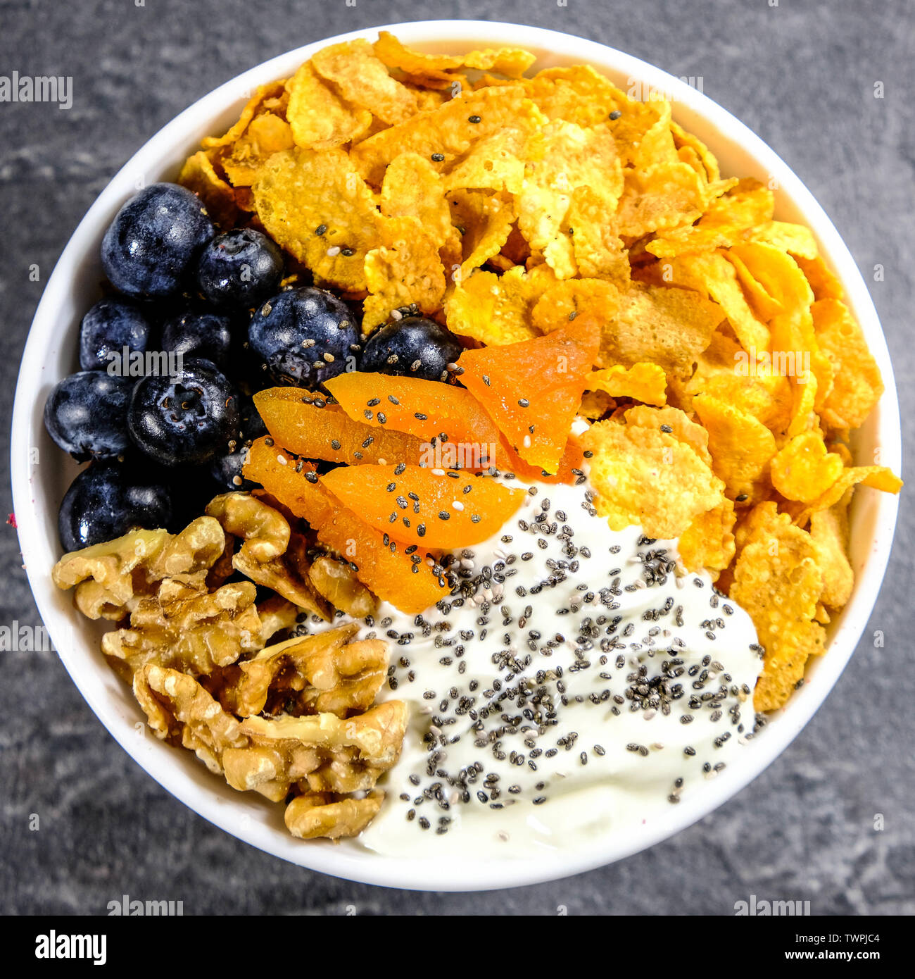 Petit-déjeuner sain bol de céréales, yaourts, abricots, noix, graines de Chia et bleuets frais Banque D'Images