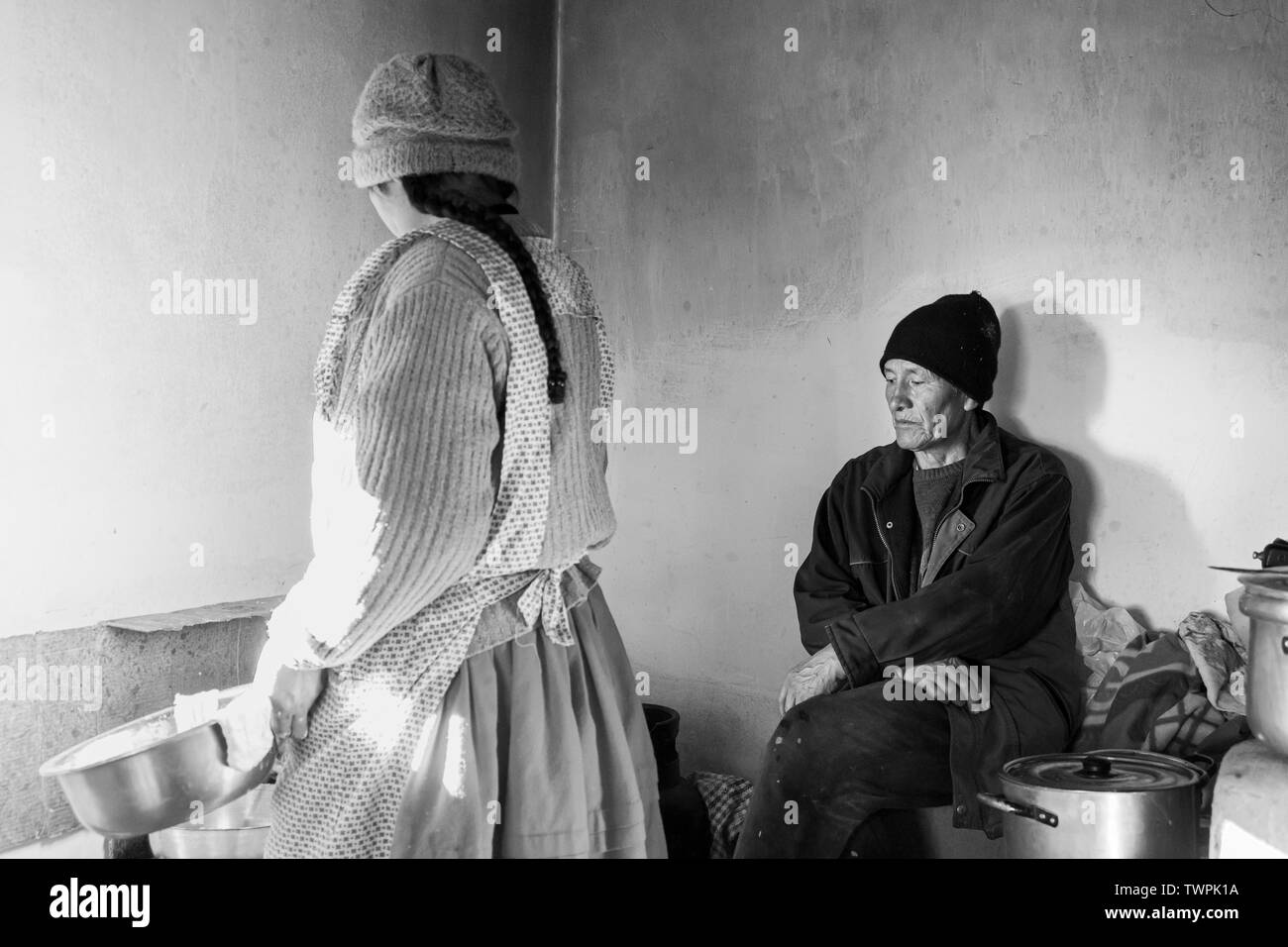 La cuisine comme femme wathchs son mari à Luquina Chico, le Lac Titicaca, le Pérou, Amérique du Sud Banque D'Images
