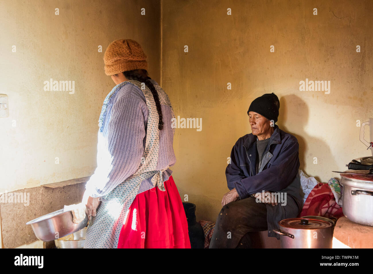 La cuisine comme femme wathchs son mari à Luquina Chico, le Lac Titicaca, le Pérou, Amérique du Sud Banque D'Images