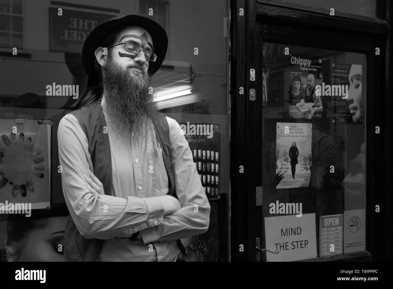Un danseur est Morris vêtements colorés et sportifs une barbe complète prend un peu de repos entre les représentations à Beverley, Yorkshire, UK. Banque D'Images