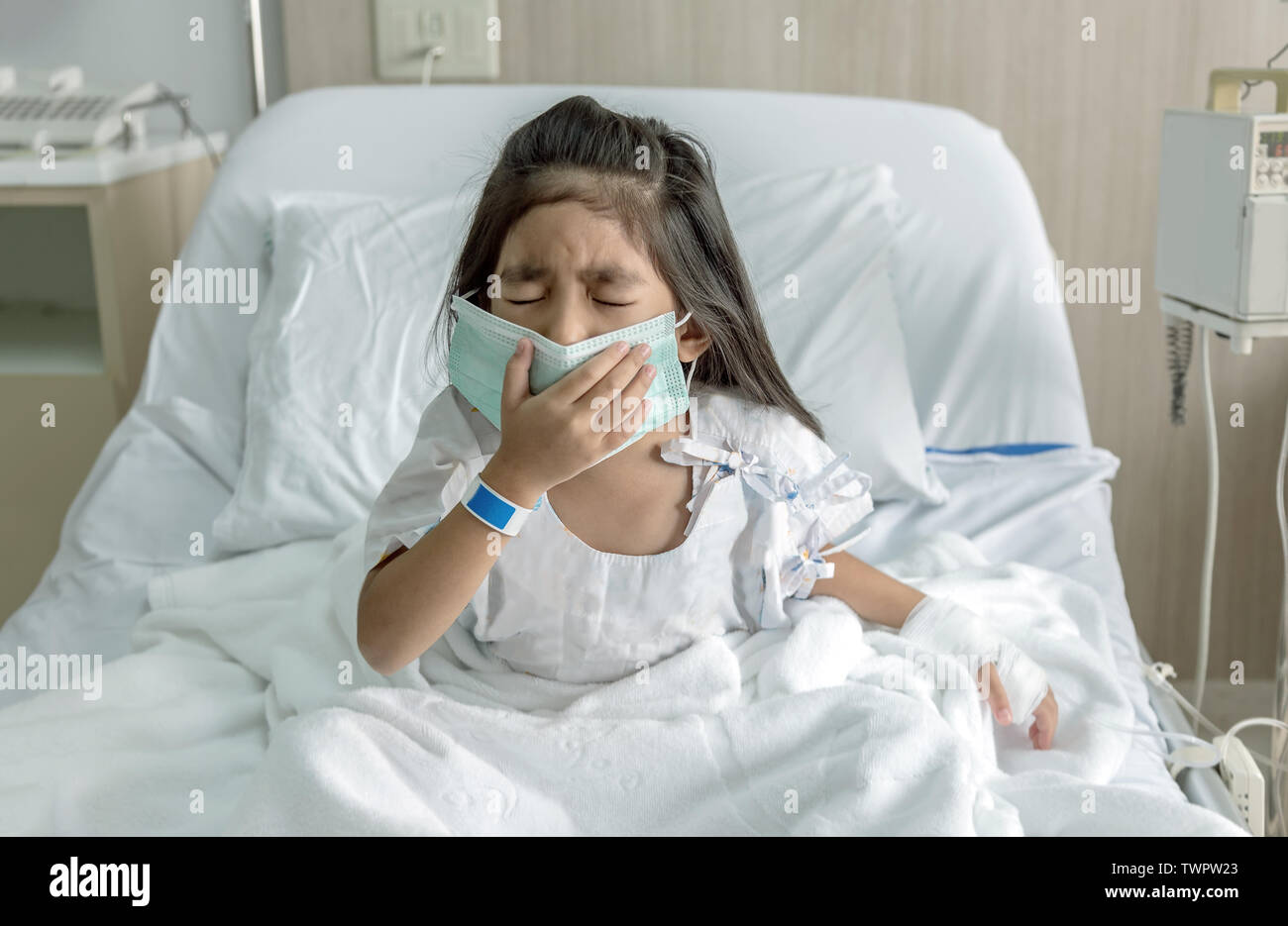 Asian kid patient tousse avec masque sur lit d'hôpital avec clinique médecin Banque D'Images