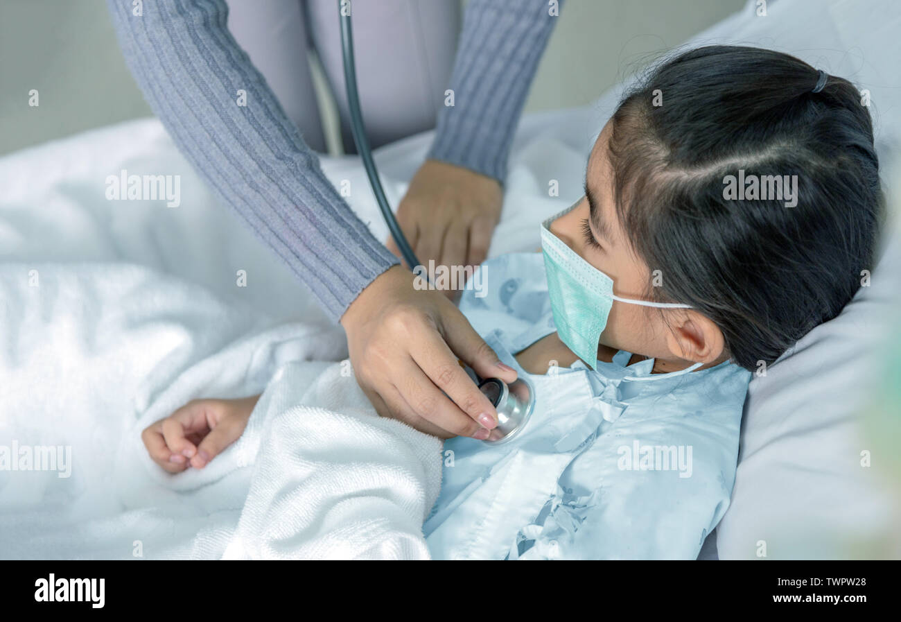 Médecin patient heal asian kid sur lit d'hôpital. Virus médecine situation lorsque kid ont une forte fièvre. Utilisation médecin stéthoscope pour entendre pulp Banque D'Images