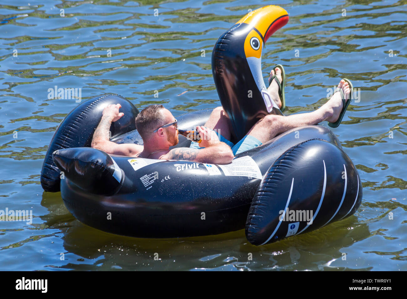 Iford, Dorset, UK. 22 juin 2019. Un temps magnifique, ensoleillé et chaud, toujours pour Dorset Canot Journée avec des centaines de jeux gonflables, des dériveurs, artisanat, conseils formant une flottille, de mettre les voiles de l'IFORD pont rivière Stour de Tuckton bridge. L'événement a commencé en 2014 comme un petit peu de plaisir, mais est maintenant devenu un événement annuel recueillant des fonds pour des organismes de bienfaisance et fonceur plus grand chaque année. Man relaxing on toucan gonflable gonflable. Credit : Carolyn Jenkins/Alamy Live News Banque D'Images