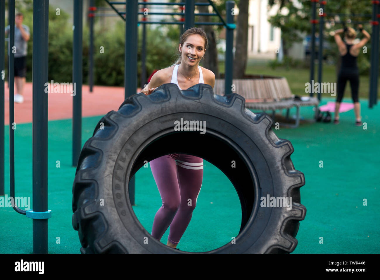 Jeune femme est la formation avec pneu sur l'aire de jeux extérieure. Et  Crossfit fitness workout extérieur Photo Stock - Alamy