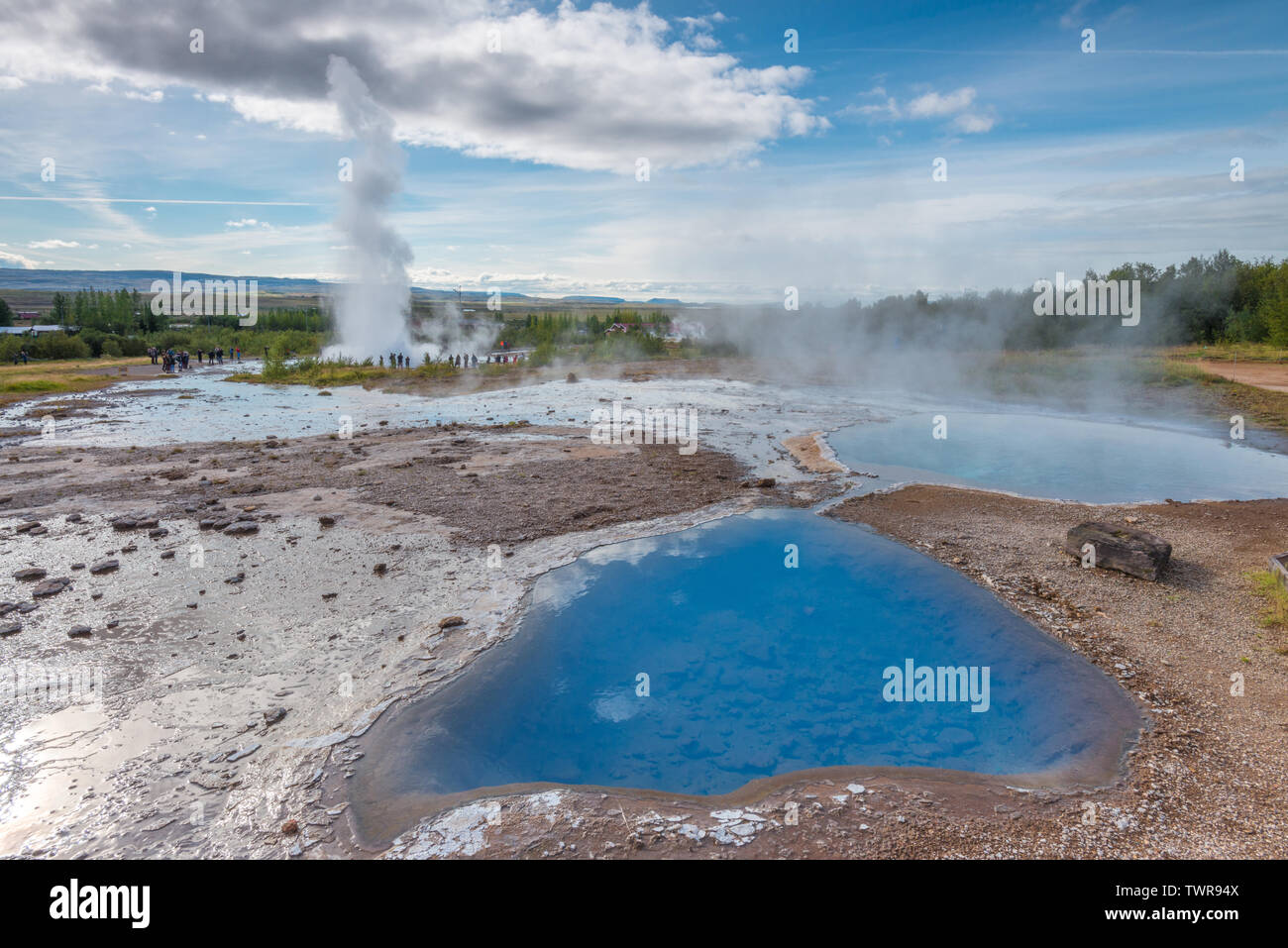 Petites piscines bleu avec de la vapeur augmente à Geysir, Islande. Lors de l'éruption du geyser célèbre destination touristique en Islande de l'intérieur. Les touristes le long de la promenade. Banque D'Images