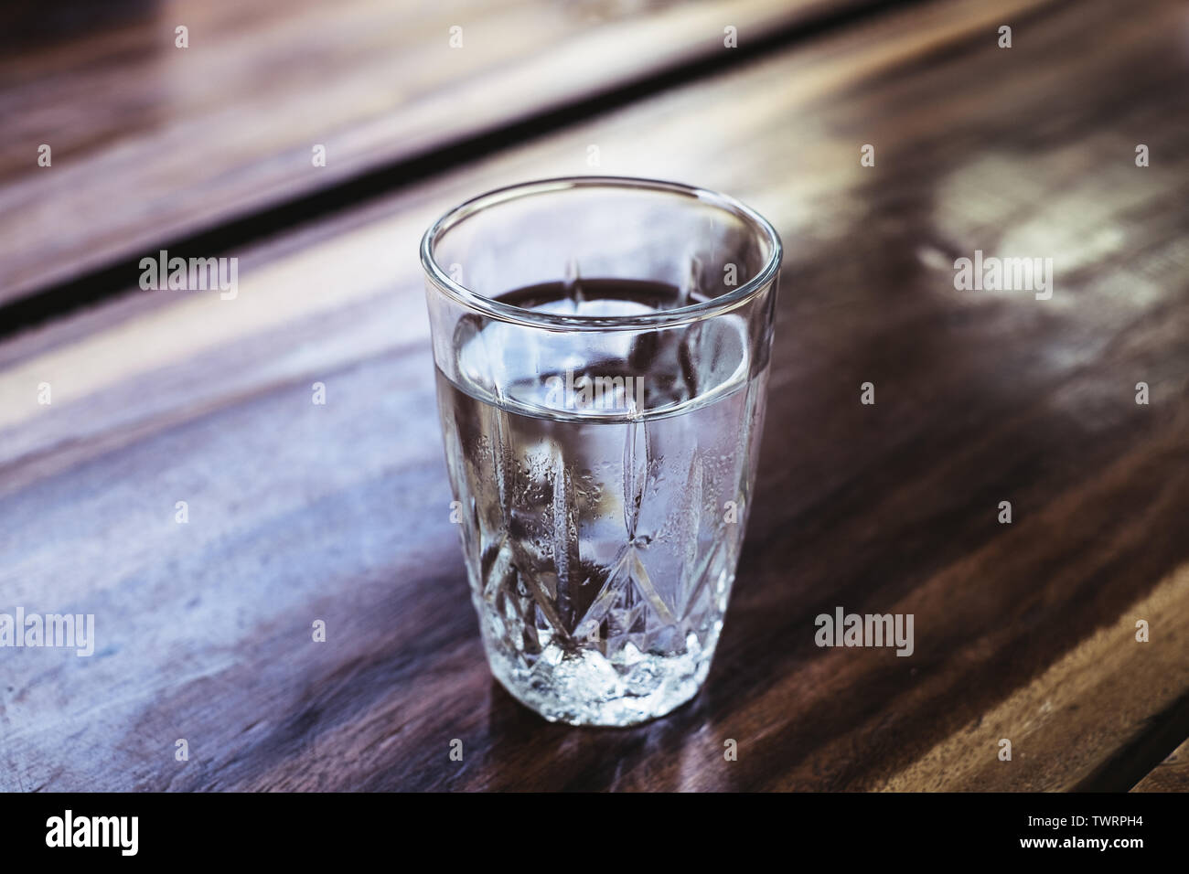 Nettoyage complet de boire dans un verre d'eau sur une table en bois. L'eau est indispensable à nos cellules de fonctionner. Focus sélectif. Copier l'espace. Banque D'Images