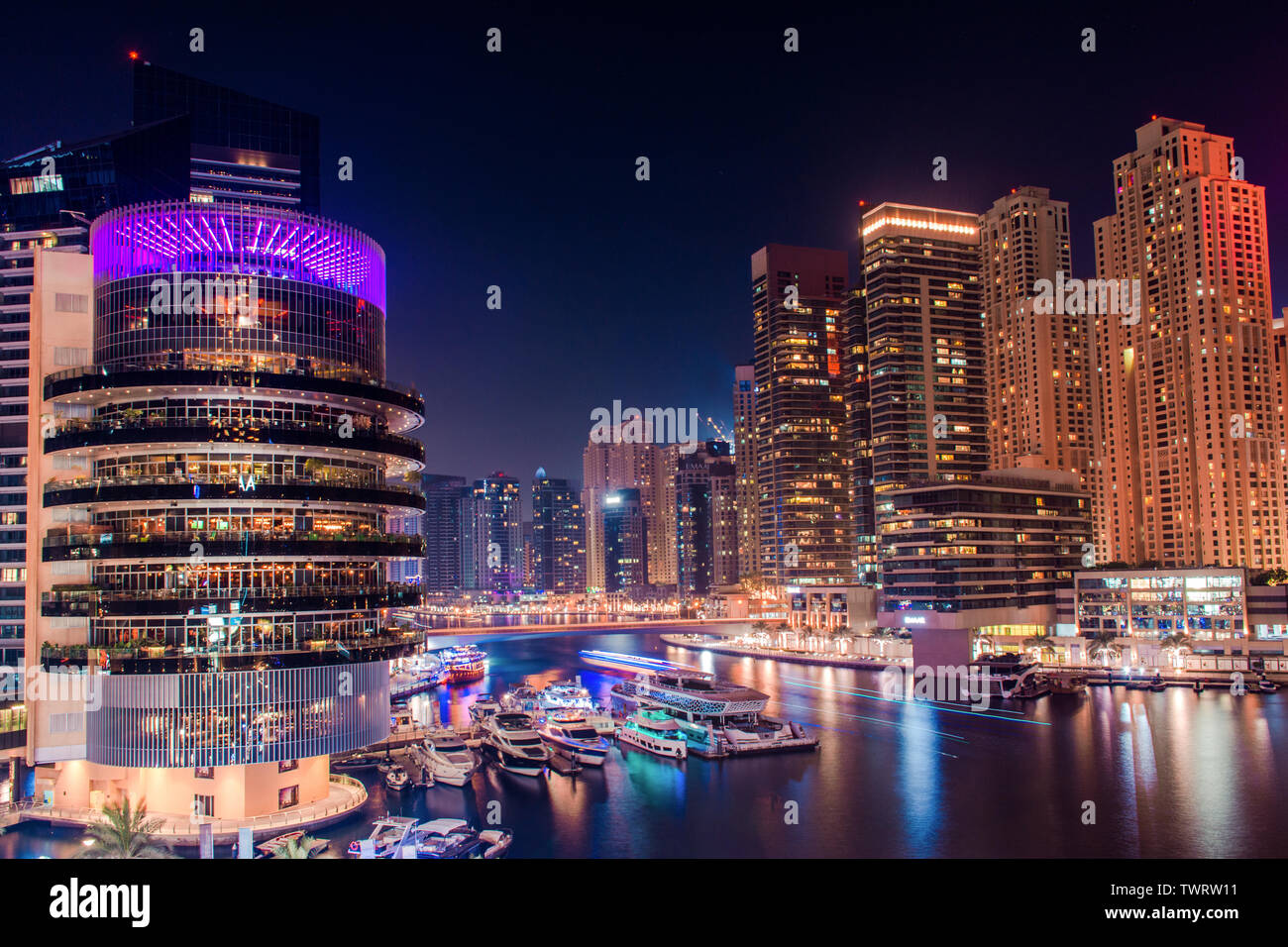 Nuit colorée vue sur la ville de Dubai Marina bâtiments modernes et le lac voile yacht de luxe, style de vie étonnante architecture meilleur endroit à visiter Banque D'Images
