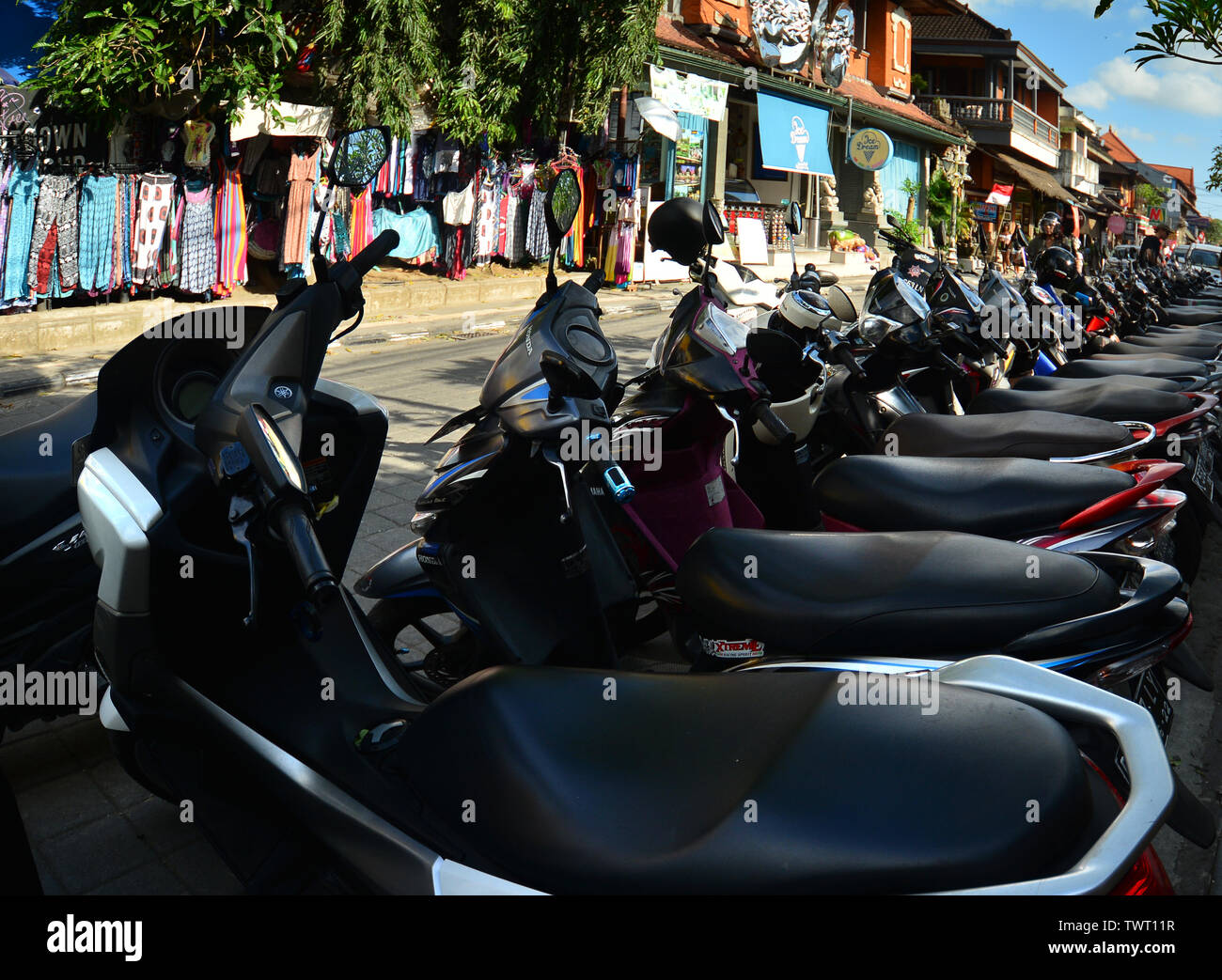 Scooters et motocyclettes parqué dans une ligne dans la ville d'Ubud, Bali. L'Indonésie Banque D'Images