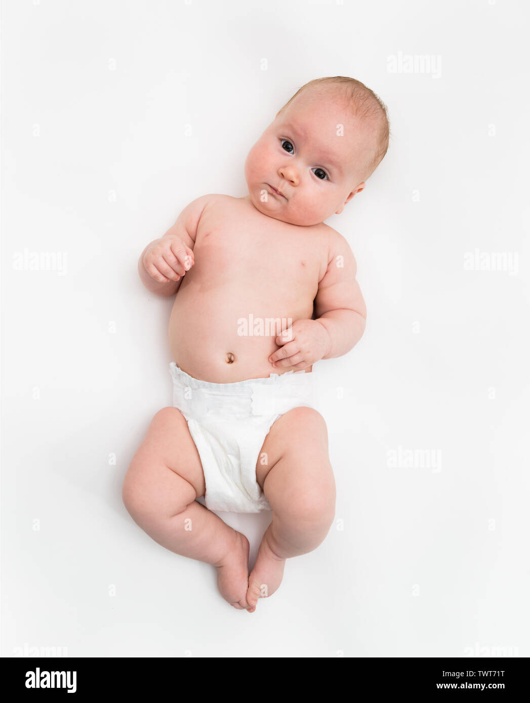 Un Mignon Bebe De Quatre Mois Fille Portant Un Couvre Couche Blanche Se Coucher Sur Fond Blanc Photo Stock Alamy