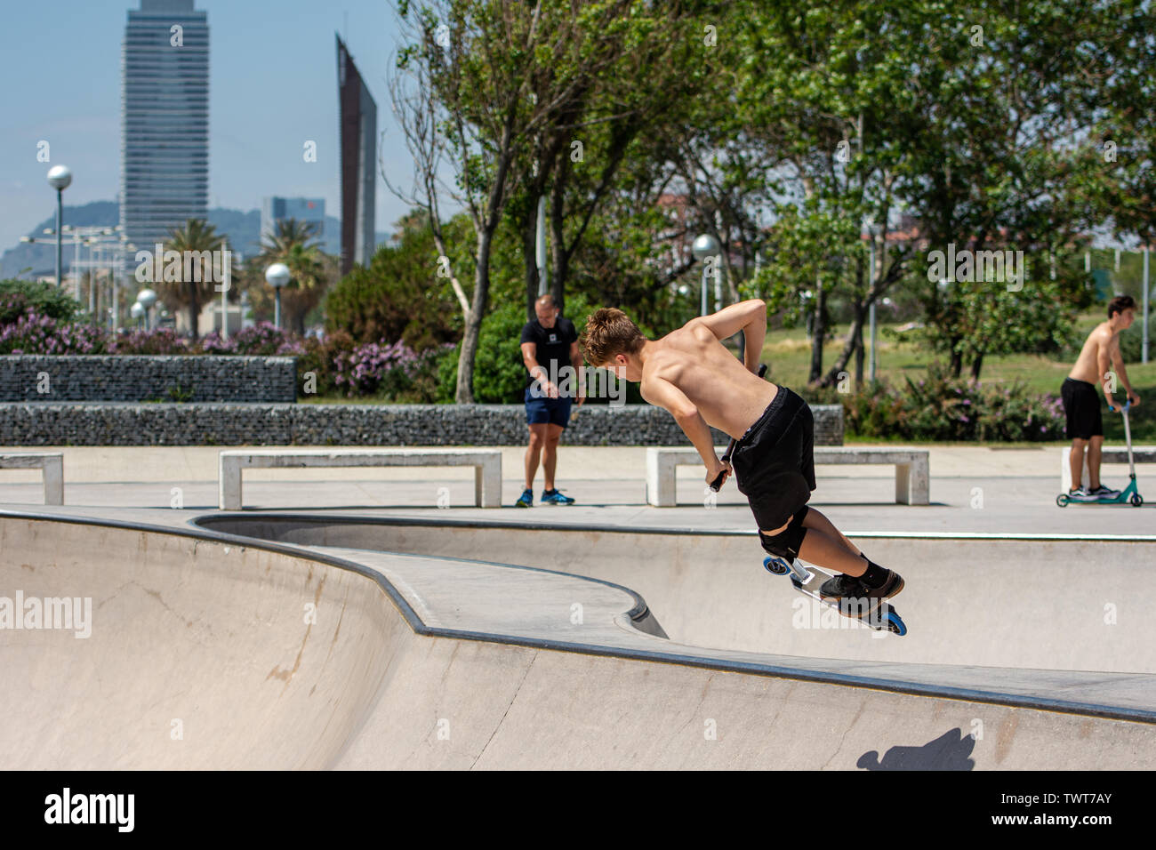 Garçon faire du sport avec scooter dans skate park Banque D'Images