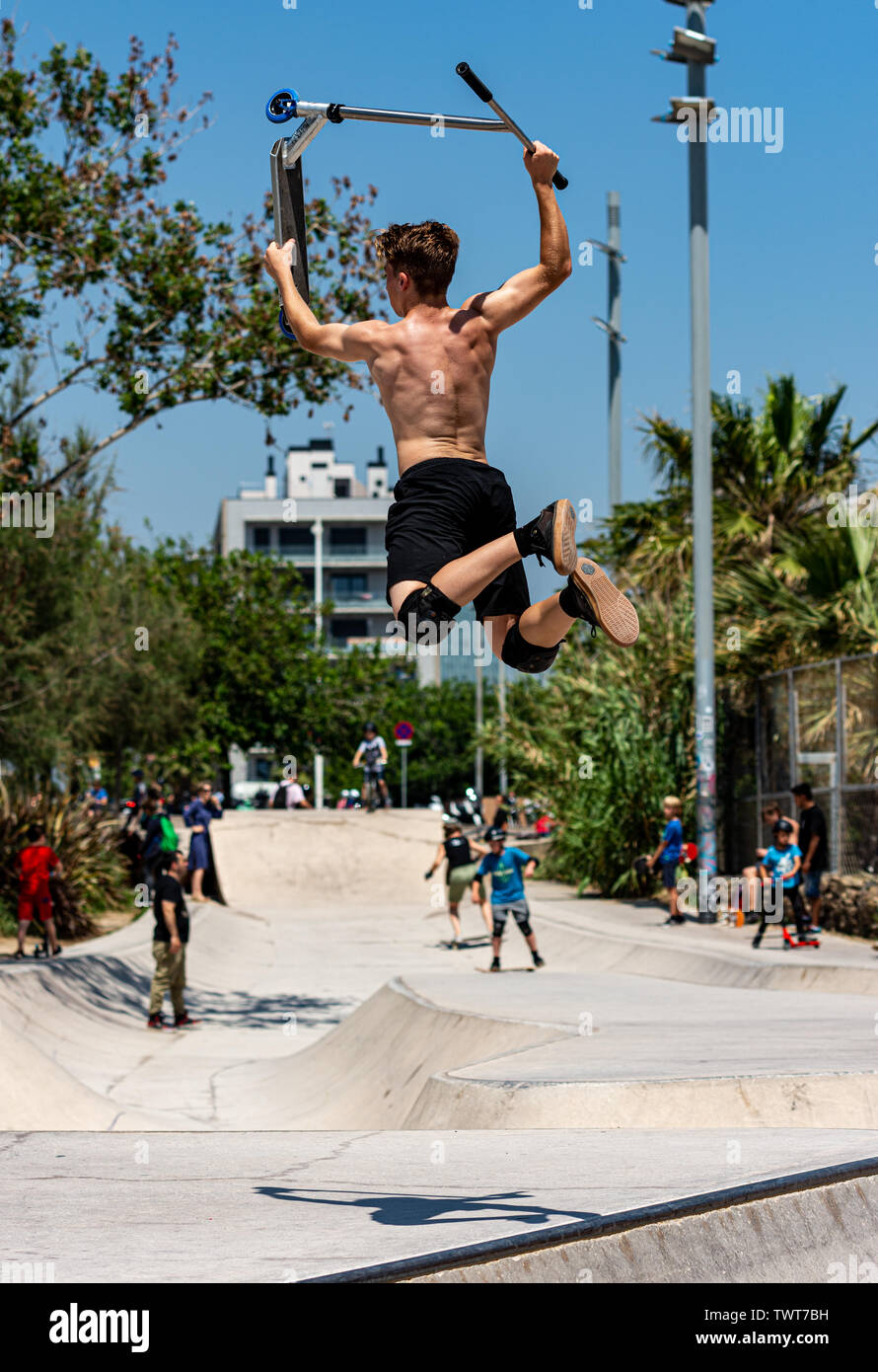 Garçon faire du sport avec scooter dans skate park Banque D'Images