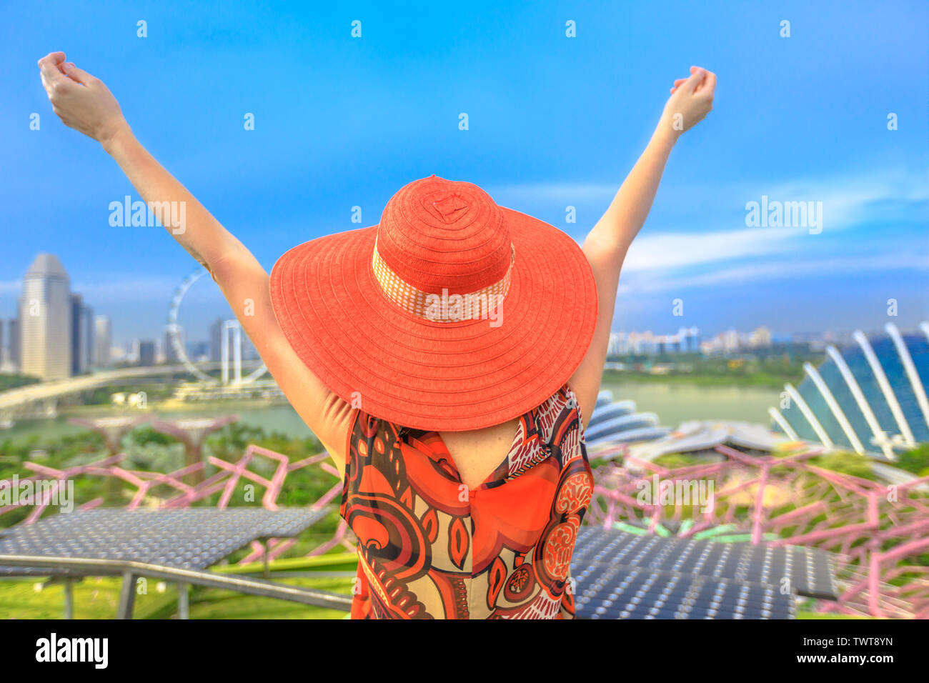 Happy woman in red hat et bras levés profiter de rues de la région de Singapour. Touristiques blonde au-dessus Vue aérienne de Singapour marina. Locations de vacances voyage Banque D'Images