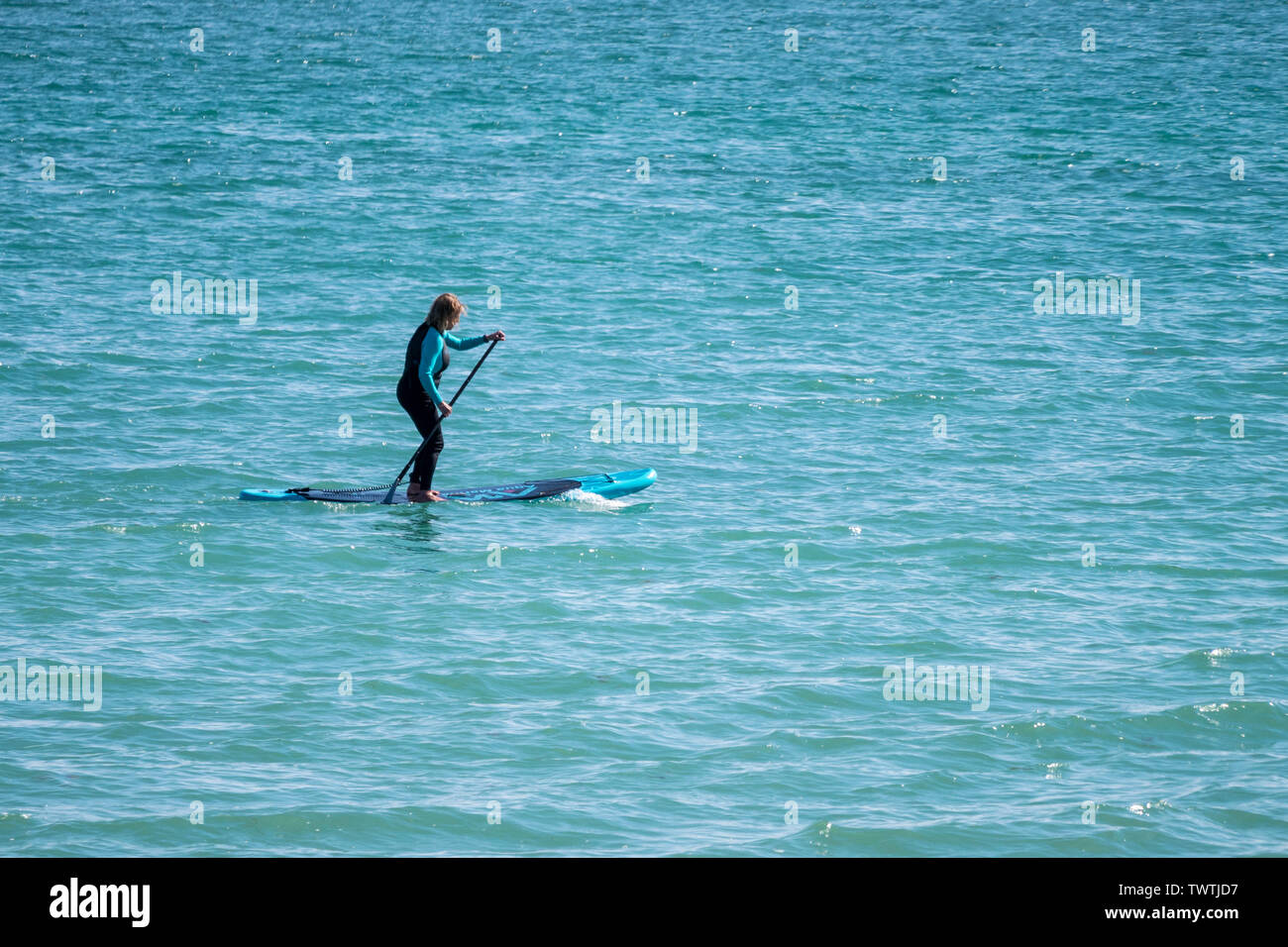 Paddleboarder bénéficie d'une ambiance chaleureuse et calme au large de la côte de Worthing, West Sussex, UK. Banque D'Images