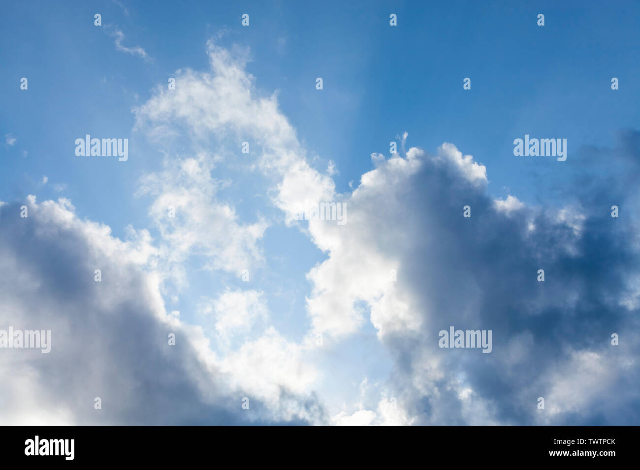 Ciel bleu avec du soleil derrière les nuages Banque D'Images
